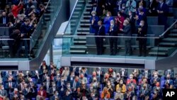 Lawmakers applaud outgoing German Chancellor Angela Merkel, center on top, in the German Parliament Bundestag in Berlin.