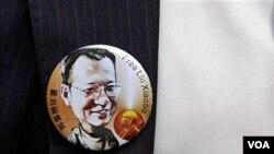 Seorang aktivis pro-demokrasi di Hong Kong mengenakan bros bergambar Liu Xiaobo, pemenang Hadiah Nobel Perdamaian tahun ini yang menjadi tahanan rumah di Beijing.