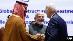 Perdana Menteri India Narendra Modi (2 kanan), Presiden AS Joe Biden (kanan) dan Putra Mahkota Arab Saudi serta Perdana Menteri Mohammed bin Salman berpegangan tangan sebelum dimulainya sesi KTT G20 di New Delhi pada 9 September 2023. (Foto : AFP)