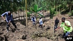 Les volontaires fuient dans les décombres, recherchant des cadavres après le débordement de la rivière Sume dans le village oriental de Wanjenwa, dans le district de Bududa en Ouganda, le 13 octobre 2018.