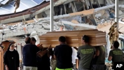 Civil Protection operators carry a casket ahead of a state funeral for some of the victims of last Wednesday's earthquake, in Amatrice, central Italy,