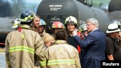 PM Kanada Stephen Harper (kedua dari kanan) mengunjungi lokasi kecelakaan di Lac Megantic, Quebec dan berbicara dengan para petugas pemadam kebakaran (7/7).