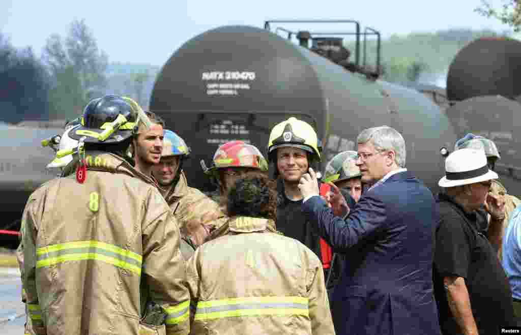 Thủ tướng Canada Stephen Harper nói chuyện với nhân viên cứu hỏa khi ông đi thị sát thiệt hại sau vụ nổ ở Lac Mégantic, Québec, Canada, 7 tháng 7, 2013.