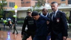 U.S. Drug Enforcement agents and Colombian police escort Luis Alfredo Carrillo Ortiz, alias "Gocho" an alleged member of the Tren de Aragua transnational gang, into a police station in Bogota, Colombia, Thursday, Feb. 6, 2025. 