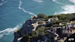 FILE - Tourists enjoy the view from Cape Point on the southern tip of the Cape Peninsula, about 50 kilometers south of Cape Town, South Africa, May 2010.