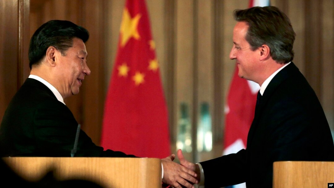 Presiden China Xi Jinping (kiri) berjabat tangan dengan PM Inggris, David Cameron, dalam konferensi pers bersama di London, Rabu (21/10).