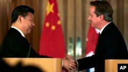 El presidente chino, Xi Jinping (izquierda) estrecha la mano del primer ministro británico, David Cameron durante una conferencia de prensa en Londres, el miércoles 21 de ocutbre de 2015.
