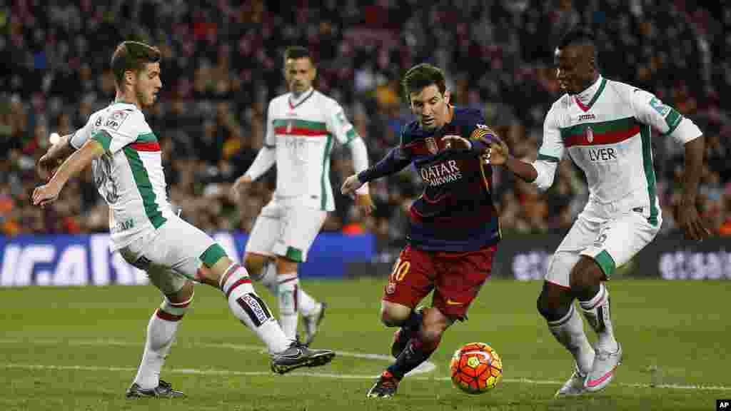 Lionel Messi du FC Barcelone, deuxième à droite, se livre une phase de drible qu&rsquo;il affactionne, devant Thievy Bifoumaz de Grenade, à droite, lors d&#39;un match de football de la Liga espagnole au stade Camp Nou à Barcelone, Espagne, 9 janvier 2016.