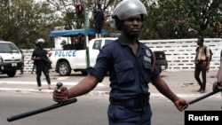 FILE - Police officers stand guard as protesters march in Ghana's capital Accra against the expansion of its defence cooperation with the United States, Ghana, March 28, 2018. 