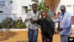 People assist a girl wounded in a suicide blast at popular restaurant in Mogadishu, November 3, 2012.