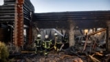 Firefighters work at a site of a Russian drone strike in Kyiv