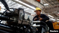 FILE - An employee works at a manufacturing plant of Sany Heavy Industry Co. during a government-organised tour of manufacturers based in Changsha, Hunan province, China, Oct. 19, 2019. 