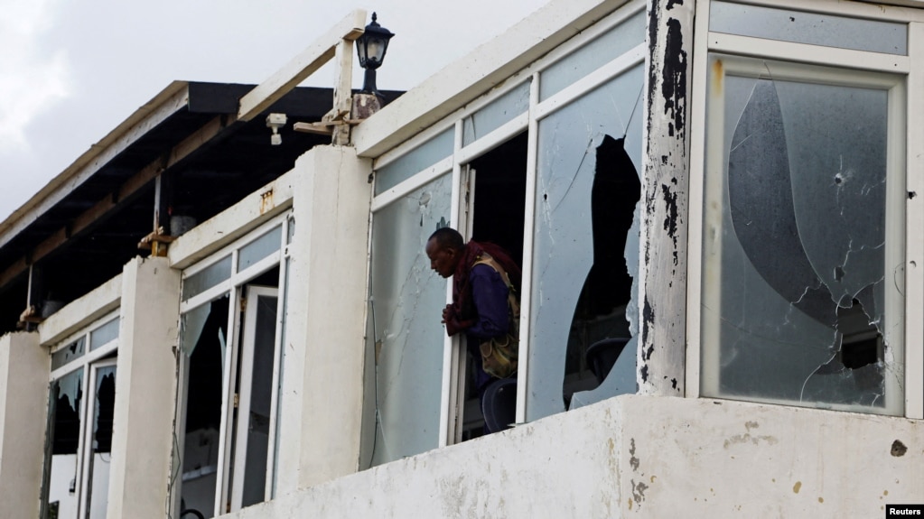 FILE PHOTO: A Somali police officer looks from the broken windows following an attack by al-Shabab militants at the Liido beach in Mogadishuu, Somalia, June 10, 2023.