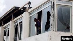 FILE PHOTO: A Somali police officer looks from the broken windows following an attack by al-Shabab militants at the Liido beach in Mogadishuu, Somalia, June 10, 2023.