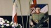 A portrait of Arkan, real name Zeljko Raznatovic, is displayed next to a couple of Serbian flags and a wreath during his commemoration service in Belgrade. Photo: Goran Tomasevic/Reuters.