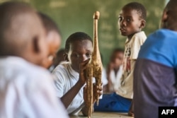 FILE— A grade three pupil, Kholwani Ndebele, plays with a broken wooden giraffe in a classroom at Mabale Primary near Hwange National Park in Hwange on March 7, 2024.