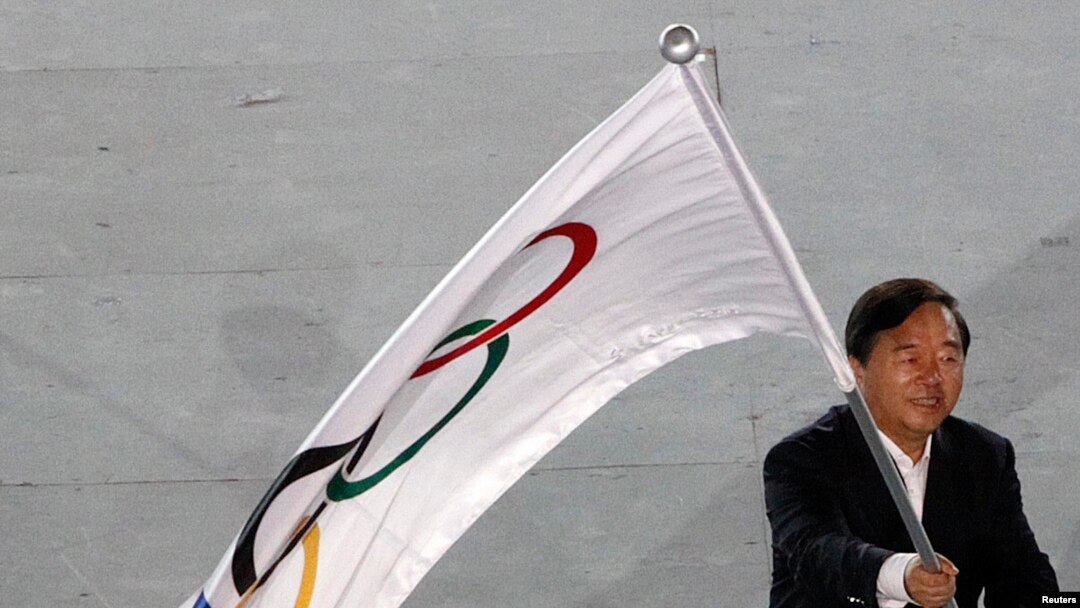 Walikota Nanjing, Ji Jianye, melambaikan bendera olimpiade, sesaat setelah menerimanya dari Presiden Komite Olahraga Internasional (IOC), Jacques Rogge (tidak nampak dalam foto), dalam upacara penutupan Olimpiade pemuda (YOG) di Singapura, 26 Agustus 2010 (Foto: dok). 