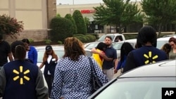 imagen provista por WREG-TV, muestra a empleados de Walmart en un círculo de oración afuera de la tienda, el martes 30 de julio de 2019, en Southaven, Mississippi, luego de un tiroteo. (Jerrita Patterson/WREG-TV via AP).