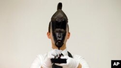 Un employé de Christie's tient «Le masque Mendes-France Baule» de Côte d'Ivoire dans les salles des ventes Christie's à Londres, le 11 avril 2016.