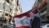 یک مرد سنی پوستر وسام الحسن، رئیس اطلاعات پلیس لبنان را در دست دارد که در انفجار روز جمعه در بیروت کشته شد.