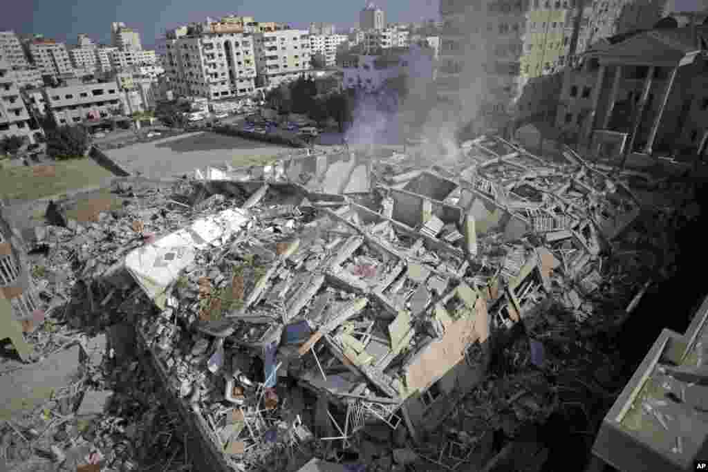 Smoke rises from the rubble of the Al-Zafer apartment tower following Israeli airstrikes Saturday that collapsed the 13-story building, in Gaza City, Sunday, Aug. 24, 2014.
