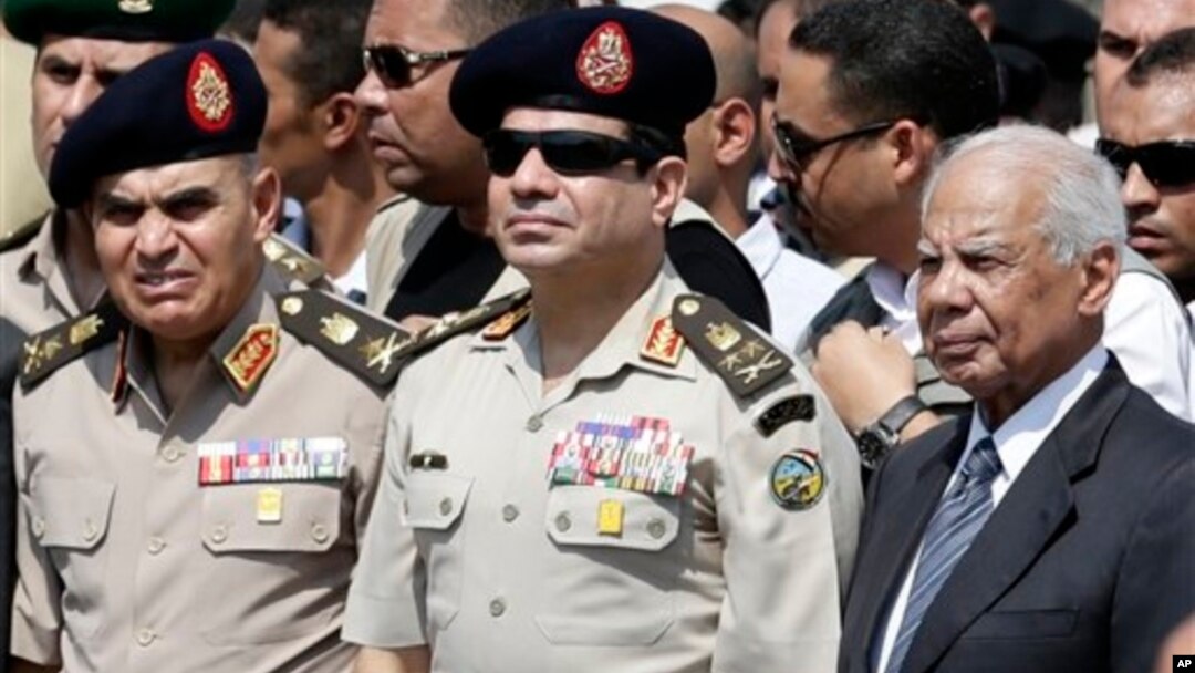 Menhan Mesir, Abdel-Fattah el-Sissi (tengah) bersama Perdana Menteru Hazem el-Beblawi (kanan) pada upacara pemakaman Kepala Polisi Giza, Nabil Farrag, di Kairo (foto: dok). 