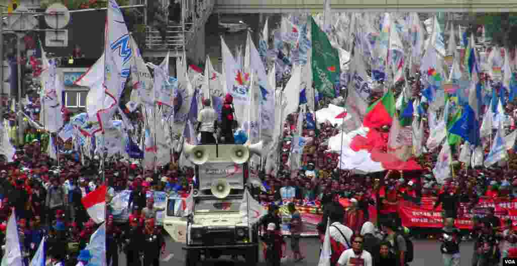 Massa buruh dari wilayah Jabotabek berbaris dari Bundaran HI menuju Istana Merdeka, Jakarta (1/5). (VOA/Ahadian Utama)