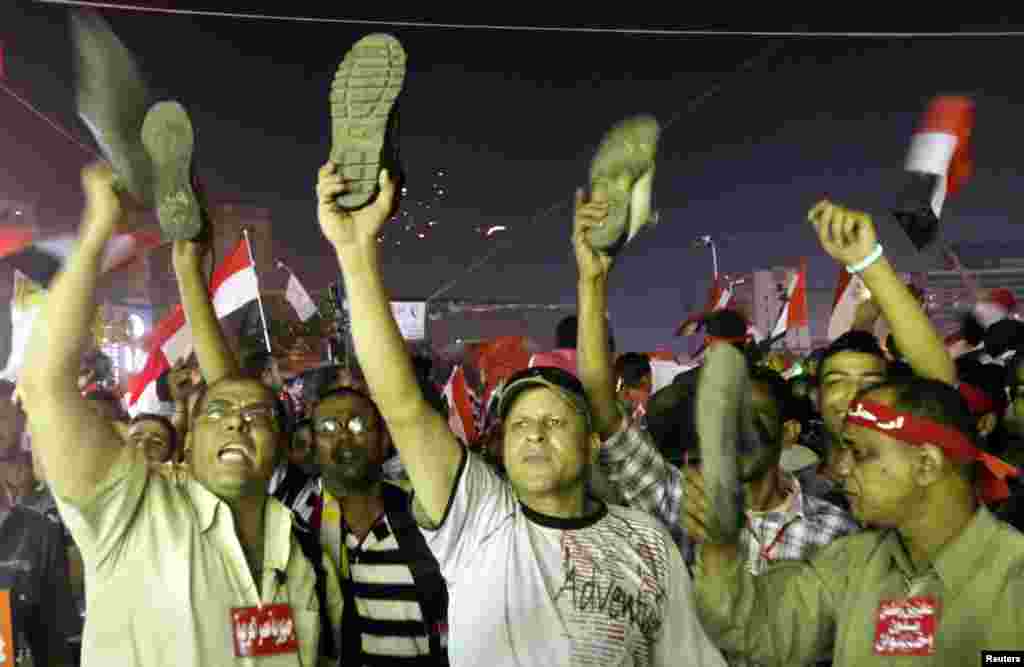 Demonstran penentang Mohammed Morsi di Alun-Alun Tahrir, Kairo, mengangkat sepatu mereka menyusul siaran pidato Morsi di stasiun televisi pemerintah (3/7).