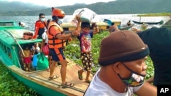 In this Philippine Coast Guard photo, families are evacuated to safer ground in Camarines Sur province, eastern Philippines, Oct. 31, 2020, as Typhoon Goni approaches.