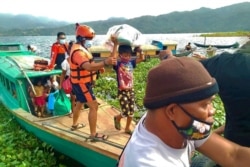 In this Philippine Coast Guard photo, families are evacuated to safer ground in Camarines Sur province, eastern Philippines, Oct. 31, 2020, as Typhoon Goni approaches.