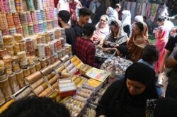 Women buy jewelry at the Baghbanpura Bazaar ahead of the Muslim Eid al-Fitr festival in Lahore, Pakistan, May 21, 2020.