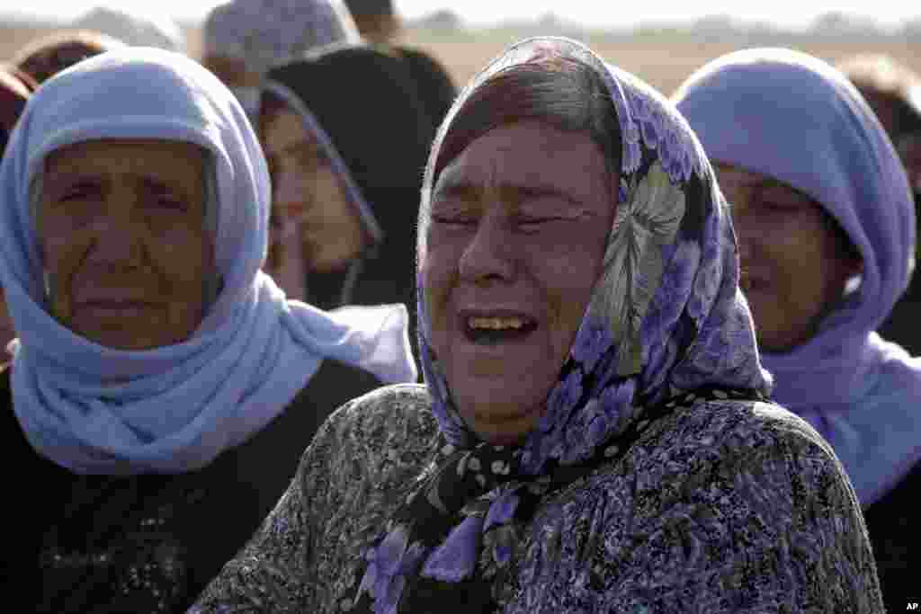 A Kurdish woman weeps as she mourns during the funeral of three Kurdish fighters, killed while fighting Islamic State militants, Suruc, Turkey, Oct. 23, 2014. 