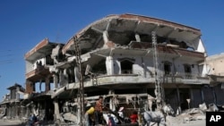 FILE - The remains of buildings line a street that was damaged last summer during fighting between U.S.-backed Syrian Democratic Forces fighters and Islamic State militants, in Raqqa, Syria, April 5, 2018. 