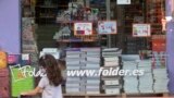 A young girl wearing a face mask walks past a store displaying a coronavirus information poster and selling children's school stationery, backpacks, protective masks and hand sanitizers in Madrid, Spain, Monday, Aug. 24, 2020.