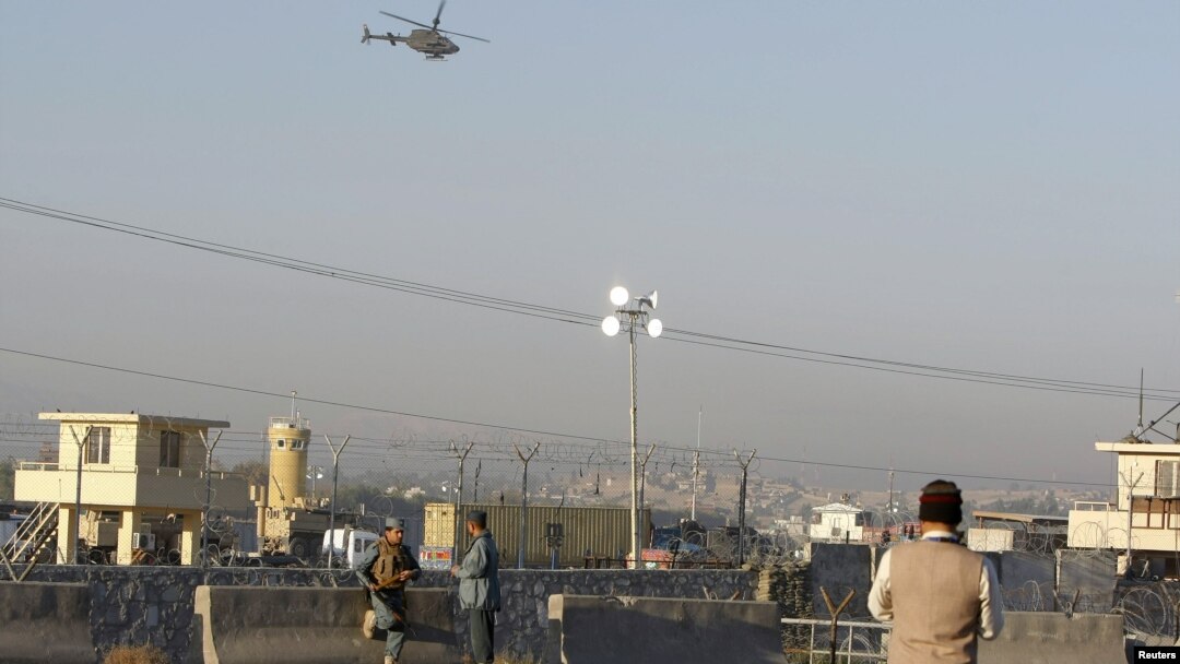 Petugas keamanan Afghanistan melakukan penjagaan ketat, saat helikopter NATO melintasi lokasi kejadian ledakan bom bunuh diri di Jalalabad (2/12).