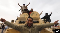 Libyan rebels celebrate on a armored personnel carrier in the strategic oil town of Ajdabiyah, March 29, 201