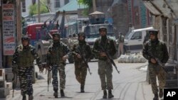 FILE - Indian paramilitary soldiers walks back towards their vehicles after gun battle with suspected rebels ended in Srinagar, Indian controlled Kashmir, May 19, 2020.