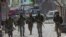 FILE - Indian paramilitary soldiers walks back towards their vehicles after gun battle with suspected rebels ended in Srinagar, Indian controlled Kashmir, May 19, 2020.