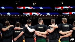 FILE - Members of Australia's team lock arms during the national anthem before their semifinal match against Spain in the FIBA Basketball World Cup at the Cadillac Arena in Beijing, Sept. 13, 2019.