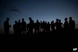FILE - Refugees who fled the conflict in the Ethiopia's Tigray gather after the sun sets in Hamdayet, eastern Sudan, near the border with Ethiopia, March 23, 2021.