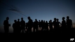 FILE - Refugees who fled the conflict in the Ethiopia's Tigray gather after the sun sets in Hamdayet, eastern Sudan, near the border with Ethiopia, March 23, 2021.