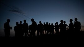 FILE - Refugees who fled the conflict in the Ethiopia's Tigray gather after the sun sets in Hamdayet, eastern Sudan, near the border with Ethiopia, March 23, 2021.