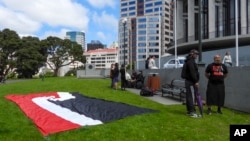 Protesters against the Treaty Principles Bill stand by a Maori sovereignty flag outside Parliament in Wellington, New Zealand, Nov. 14, 2024