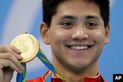 FILE - Joseph Schooling dari Singapura memamerkan medali emasnya dalam upacara penyerahan medalisetelah memenangkan pertandingan gaya kupu-kupu 100 meter putra Olimpiade Musim Panas 2016, di Rio de Janeiro, Brazil, 12 Agustus 2016. (Michael Sohn/AP)