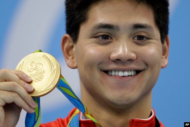 FILE - Joseph Schooling dari Singapura memamerkan medali emasnya dalam upacara penyerahan medalisetelah memenangkan pertandingan gaya kupu-kupu 100 meter putra Olimpiade Musim Panas 2016, di Rio de Janeiro, Brazil, 12 Agustus 2016. (Michael Sohn/AP)