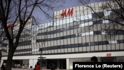 Orang-orang berjalan melewati toko asal Swedia H&M di kompleks perbelanjaan di Beijing, China, 25 Maret 2021. (Foto: REUTERS/Florence Lo)