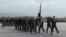 In this photo provided by the Russian Defense Ministry Press Service, Syrian troops march during a send-off ceremony for Russian troops at Hemeimeem air base in Syria, March 15, 2016.