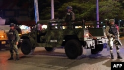 FILE - Mexican army soldiers secure a local area after an armed confrontation between the Ministerial Police and criminal groups in the downtown area of Cancun, Quintana Roo State, Mexico, June 15, 2017. 