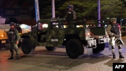 FILE - Mexican army soldiers secure a local area after an armed confrontation between the Ministerial Police and criminal groups in the downtown area of Cancun, Mexico. June 15, 2017. 