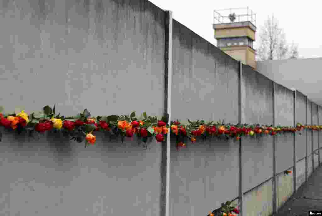 دیوار برلن پر لوگوں کی جانب سے مختلف قسم اور رنگوں کے پھول رکھے جاتے ہیں۔